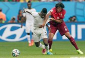 迦納球員Asamoah Gyan試著擺脫對手糾纏