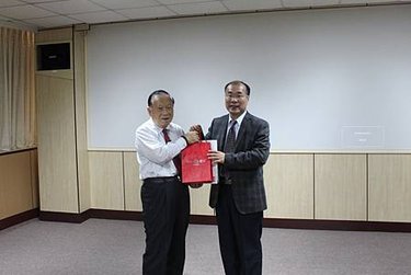 創辦人李正合(左)，代表崑山科大致贈禮品予廣西外 國語學院副校長潘連鄉(右)。