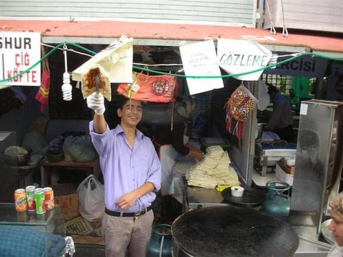 從巴士上往外拍，正在做烤餅的年輕人