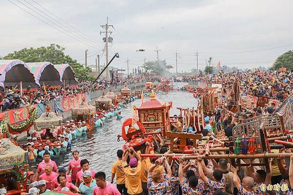 嘉義縣布袋鎮新塭嘉應廟舉行「衝水路迎客王」祭典，轎夫們扛神轎