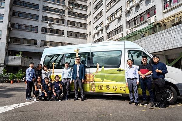 香港復康會人員在伊甸「圓夢憩旅」的車子前合影。