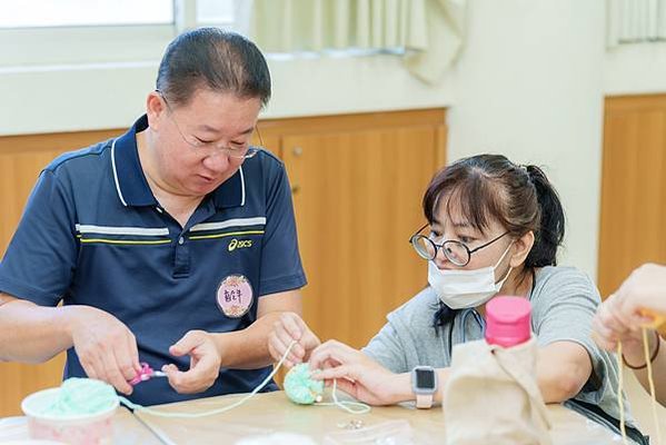 06205圖說：家長邊作毛線球，邊話家常。