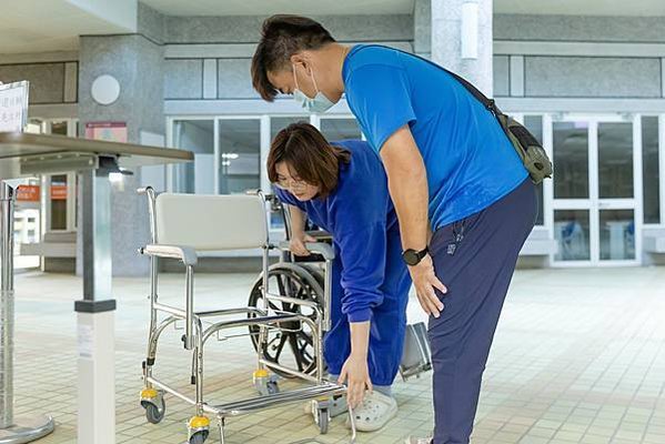 43圖說：職能治療師(左)說明便盆椅使用方式。