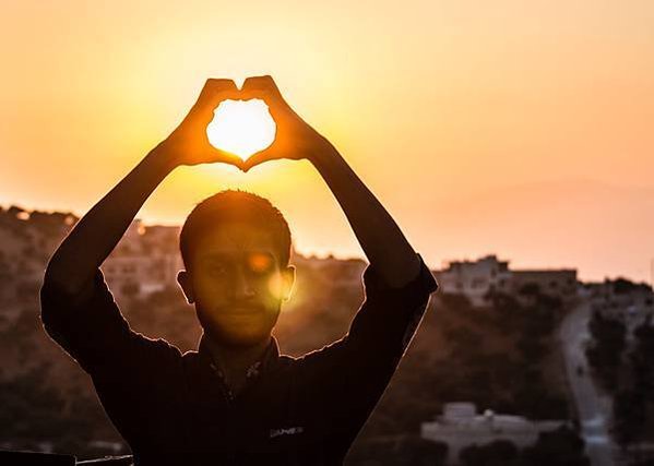 person-making-heart-shape-with-his-hand-during-sunset-705209