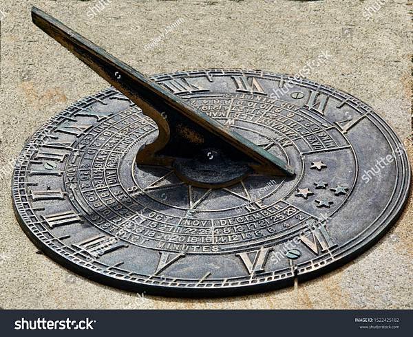 stock-photo-closeup-view-of-a-sundial-with-sun-casting-a-shadow-on-the-clock-face-dial-1522425182