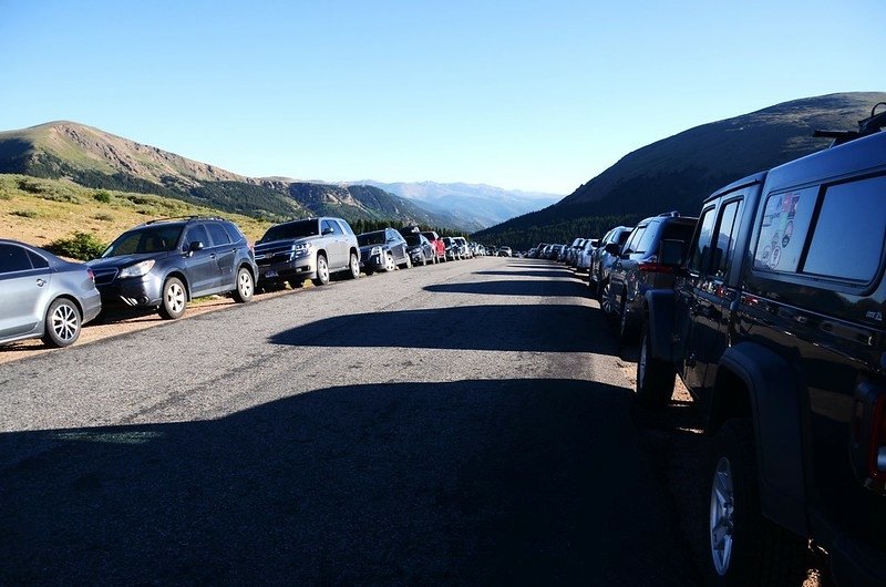 Crowded vehicles parked on both sides of the road