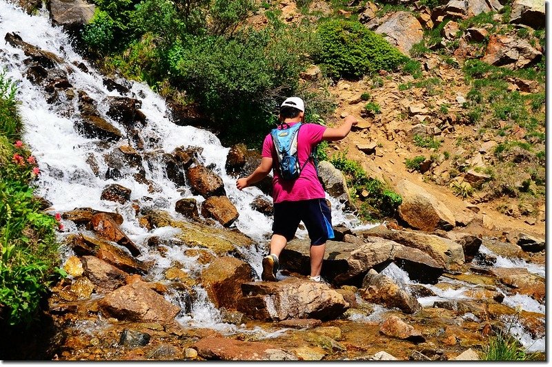 Jacob crossing a waterfall stream on the Arapaho Pass trail 1