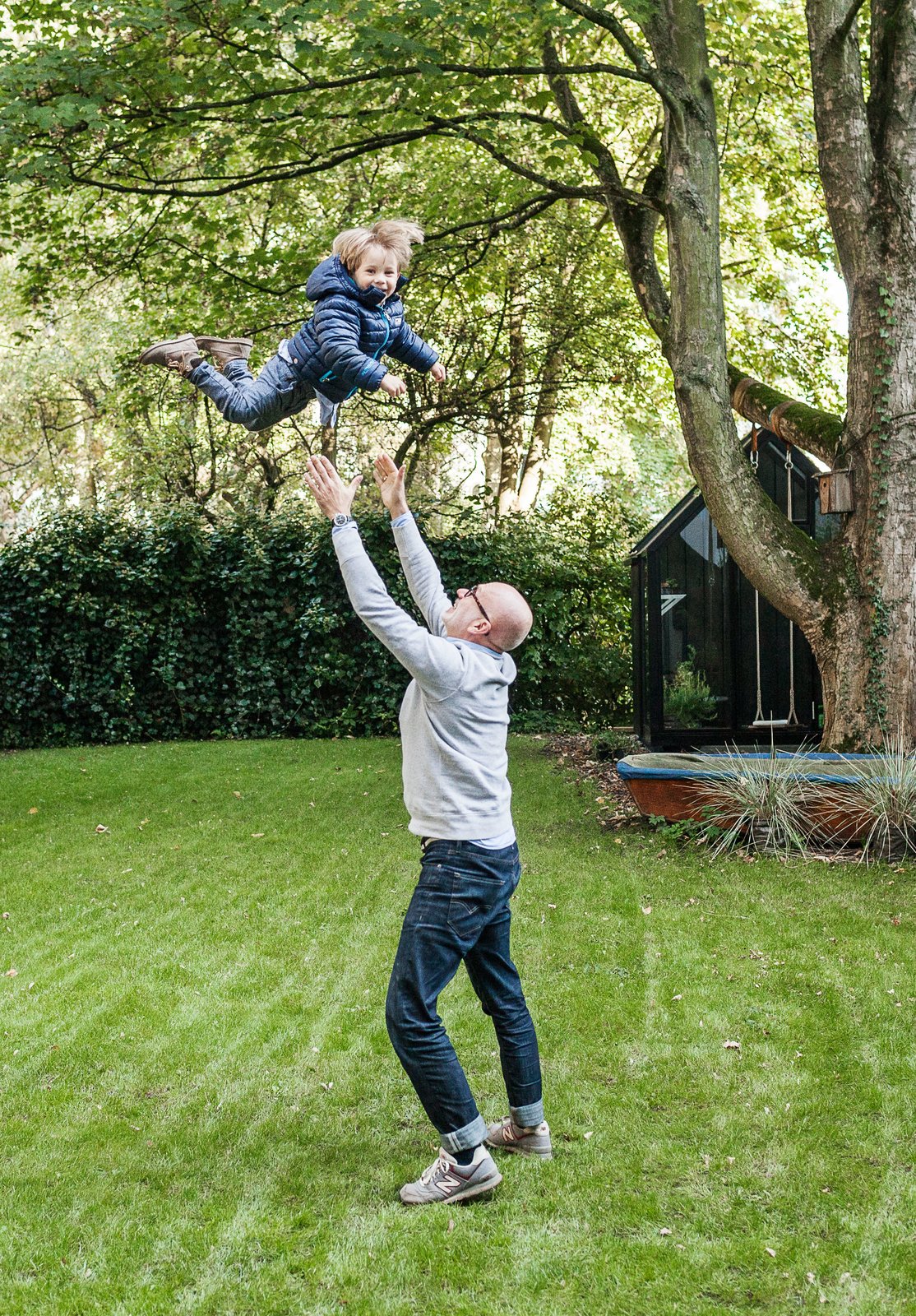 Fabian plays with Morten in the yard, which features a spacious lawn and a greenhouse.