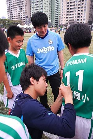 松岡球員幫黎明國小球員簽名在球衣上