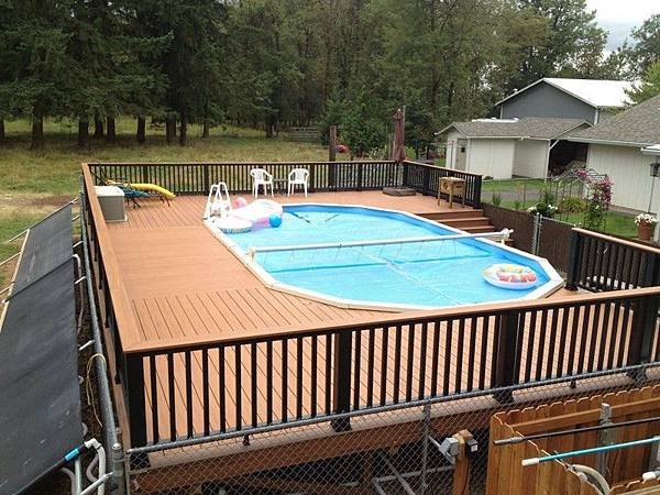 Contemporary-oval-above-ground-pool-with-wooden-deck-and-railing.jpg