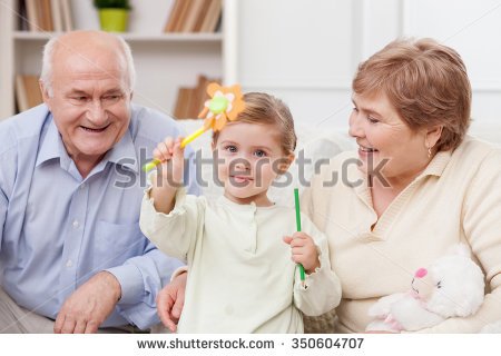 stock-photo-cute-small-girl-is-sitting-on-the-sofa-with-her-grandparents-she-is-holding-pen-and-pencil-with-350604707