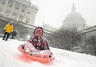 美國首都華盛頓19日遭遇百年來最大的一場暴風雪，一名幼童在國會山莊西側以自製的雪撬滑雪。（路透）.jpg