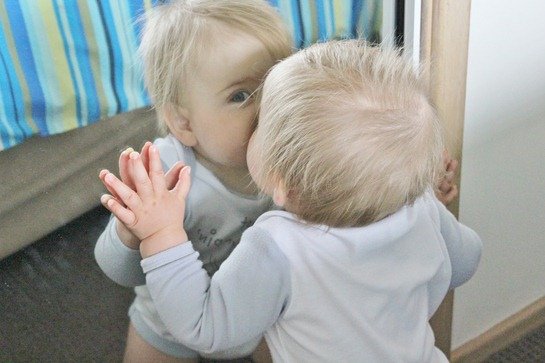 baby kissing mirror