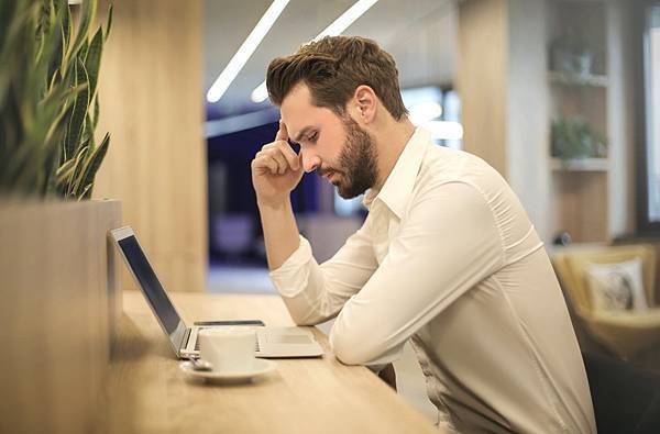 man-with-hand-on-temple-looking-at-laptop-842554.jpg