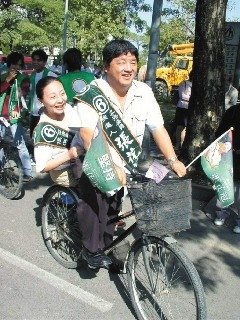 曾振農太太張花冠競選“立委”連任時，他騎腳踏車載著妻子兜風造勢