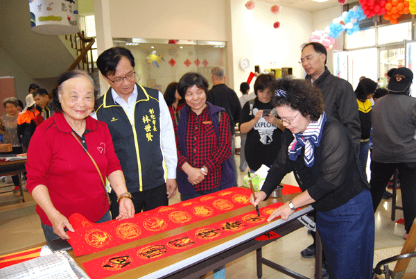 彰化市立圖書館舉行現場揮毫送春聯活動林世賢在場欣賞.png