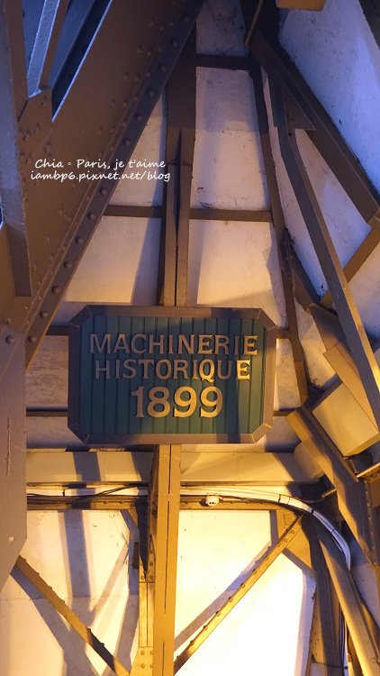 巴黎鐵塔內部標示「Machinerie Historique 1899」的歷史機械裝置標牌，見證百年前升降系統的工藝與歷史價值。