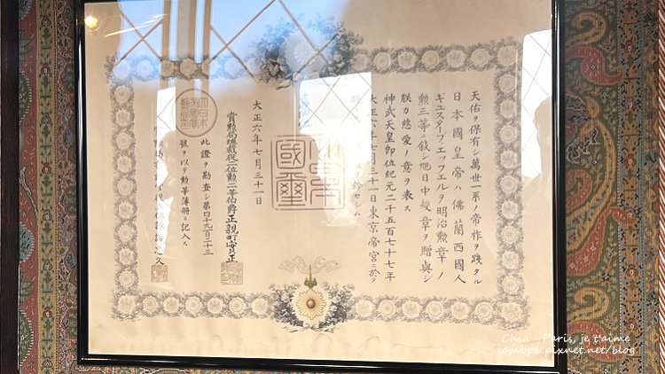巴黎鐵塔頂樓展示的日本政府頒授給居斯塔夫·艾菲爾的勳一等瑞寶章證書，表彰其對工程與國際合作的卓越貢獻。