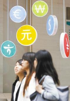 南韓央行昨天將南韓今年的GDP成長幅度，由原先預估的3.7%調降為3.5%。圖為數名南韓婦女併肩走過首爾市區韓亞銀行分行前。