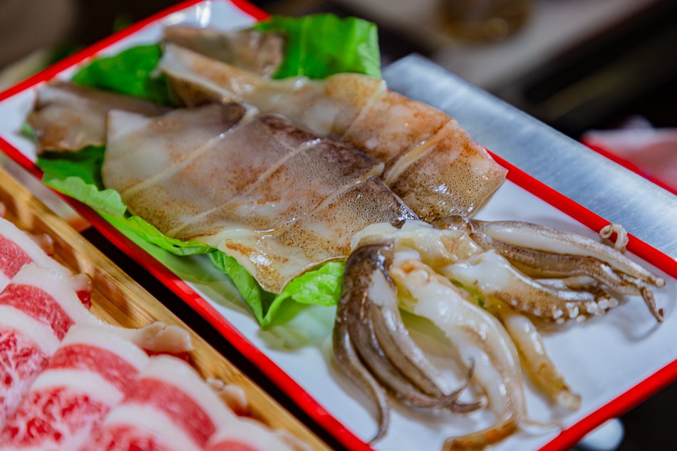 巨大魷魚展示，魷魚肉質鮮嫩彈牙，搭配生菜襯底，口感豐富