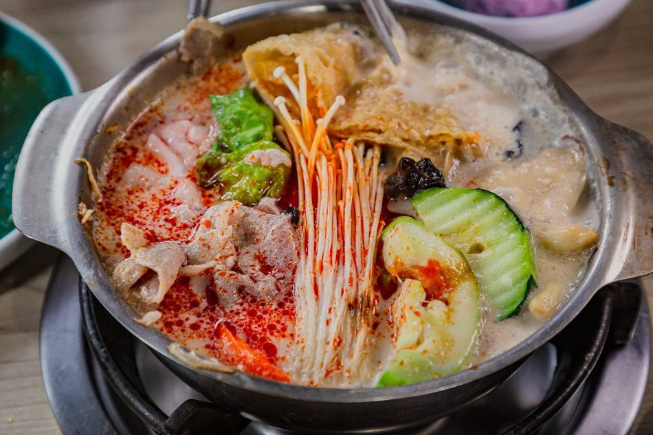 豐盛鍋中食材特寫，滑嫩豬肉與蔬菜吸附湯汁
