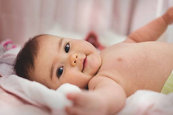 baby-lying-on-pink-bed-1556706.jpg