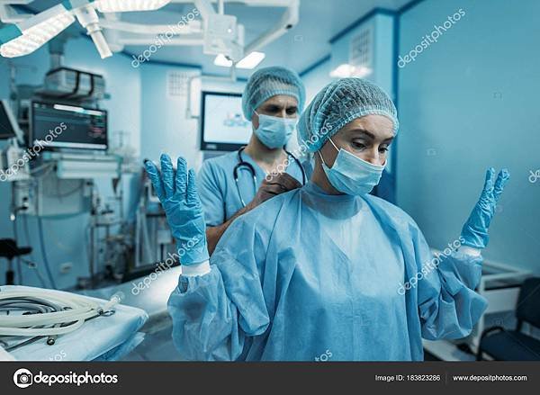 depositphotos_183823286-stock-photo-doctor-helping-wear-surgical-uniform.jpg