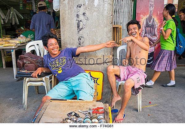 two-young-filipino-men-laughing-and-pointing-at-each-other-central-f74g61