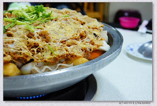 金黃蛋酥下方覆蓋著各式手工火鍋料，以及扁魚風味的湯底