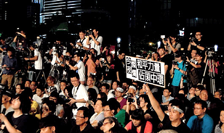 2014年09月01日香港泛民主派今晚在添馬公園發起集會，即使晚間下雨，仍超過上千名香港民眾參與，並高舉「真普選」的標語表達訴求(圖：聯合報).png