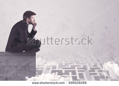 stock-photo-business-worker-sitting-on-concrete-building-edge-thinking-of-solving-a-maze-concept-with-699528289.jpg