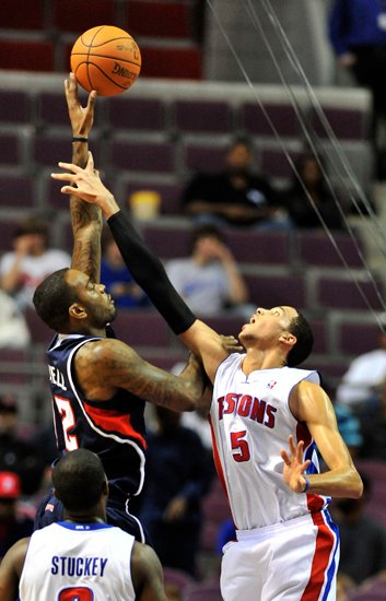 Pistons forward Austin Daye, right, tries to deflect a shot by Hawks forward Josh Powell in the first half..jpg