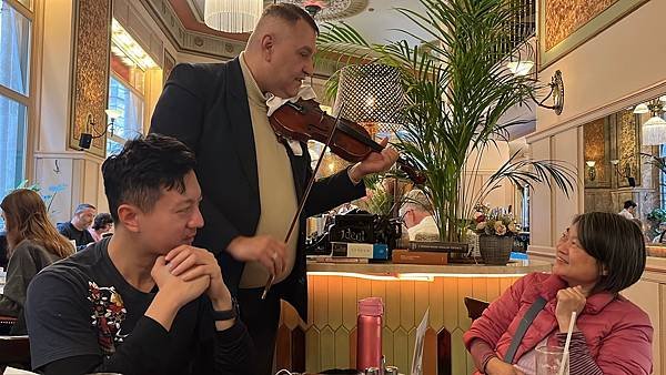 中央咖啡館內的現場鋼琴與小提琴演奏，為用餐體驗增添浪漫氛圍。