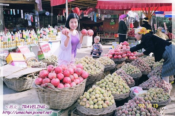 離開和田-在小村莊買水果,手拿石榴.jpg